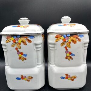 Two vintage art deco porcelain canisters with lids, orange, red, black, decor.